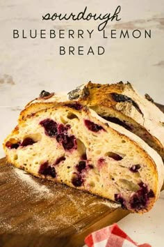 a loaf of blueberry lemon bread sitting on top of a wooden cutting board