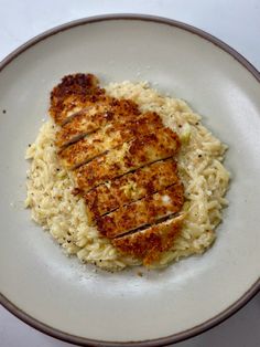 a white plate topped with meat and rice