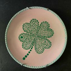 a green and white plate with a four - leaf clover design on it's side