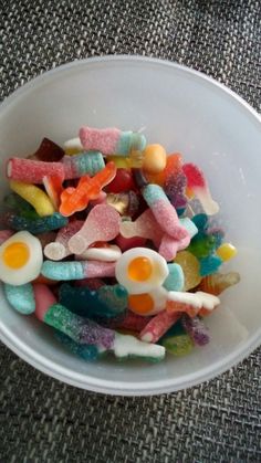 a white bowl filled with gummy bears and eggs