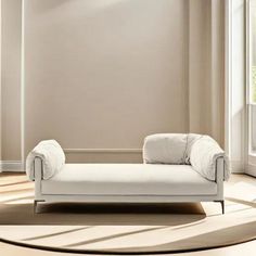 a white chaise lounge sitting on top of a rug in front of a window