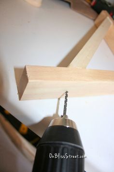 a drill is being used to make a wooden triangle