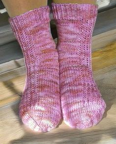 the legs of a woman wearing pink knitted socks and holding onto a wooden floor