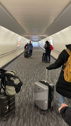 people are walking through an airport with their luggage