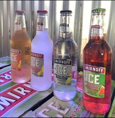 three bottles of ice water sitting on top of a wooden table