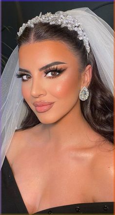 a woman in a wedding dress wearing a bridal veil and diamond headpieces