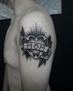 a woman's arm with a tattoo on it and the word mom in a heart