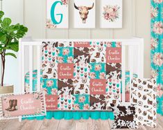 a baby crib bedding set with cow print and pink flowers on the side