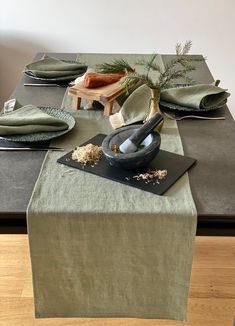 the table is set with green linens and place settings