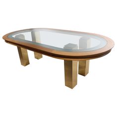 an oval glass table with gold legs and a wooden base, on a white background