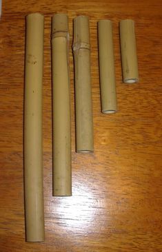 four wooden pipes are lined up on a table