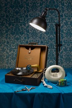 an open briefcase sitting on top of a table next to a lamp and other items