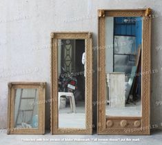 three mirrors sitting next to each other in front of a wall with an open door