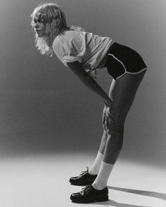 a black and white photo of a woman with her hands on her hips, leaning forward