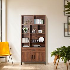 a living room with a yellow chair and wooden bookcase on the wall next to a potted plant