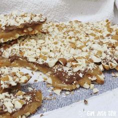 several pieces of chocolate and nuts on top of a cloth with white paper underneath it