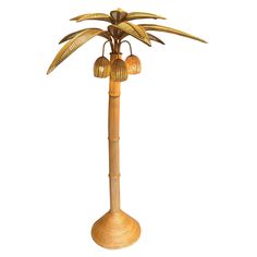 a wooden floor lamp with two lamps on it's sides and a palm tree in the middle