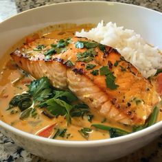 a close up of a bowl of food with fish and rice on the side,