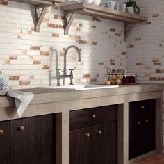 a kitchen with white brick walls and wooden cupboards on the countertop, along with an open shelving unit