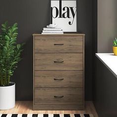 a wooden dresser sitting next to a potted plant