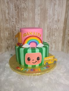 there is a cake that looks like it has a school bus and rainbow on top