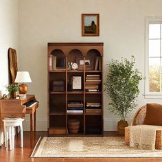 a living room filled with furniture and a book shelf on top of a hard wood floor