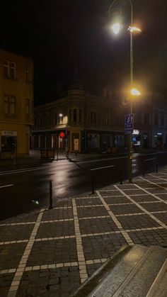 an empty city street at night with the lights on