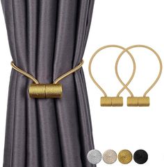 two gold and silver metal curtain clips on top of a gray curtain with three different colors