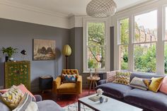 a living room filled with furniture and large windows