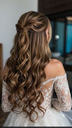 the back of a woman's head with long, wavy hair wearing a wedding dress