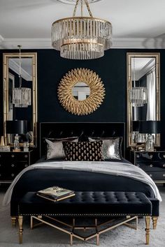 a bedroom with black walls, gold accents and chandelier over the headboard