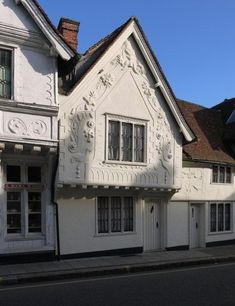 an old white building on the corner of a street