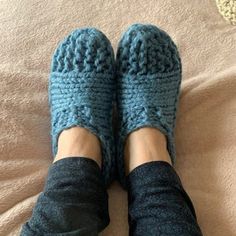 a person wearing blue slippers on top of a bed