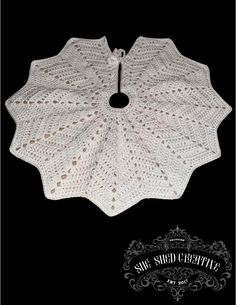 a white crocheted doily on a black background