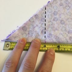 someone is measuring the length of a piece of fabric with a ruler in front of them