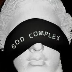 a white mannequin wearing a black headband with the words god complex on it