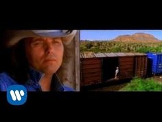 a man wearing a cowboy hat standing next to a train