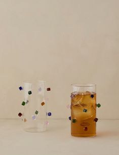 two glasses filled with liquid sitting next to each other