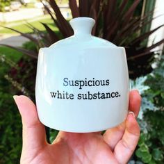 someone holding up a white ceramic jar with the words suspicious, white substance written on it