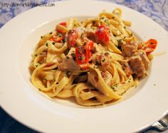 a white plate topped with pasta and meat