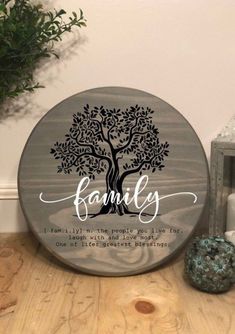 a family tree sign with the words family on it next to a potted plant