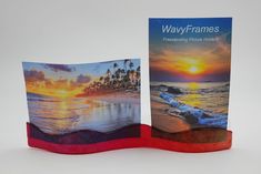 two greeting cards are placed next to each other on a wooden stand, with the sunset in the background