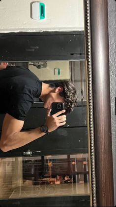 a man is taking a selfie in front of a mirror with his cell phone