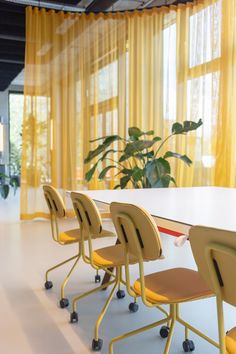 an empty conference room with yellow curtains and chairs