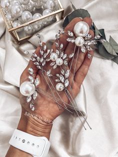 a person holding some pearls and hair pins