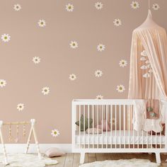 a baby's room decorated in pink and white with daisies on the wall