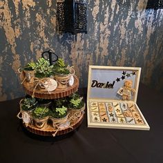 three tiered baskets with succulents and other decorations on top of a table