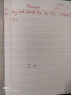 an open notebook with writing on it in red and white paper, which is lined up