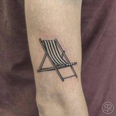 a small black and white striped chair tattoo on the right arm, with an arrow in it