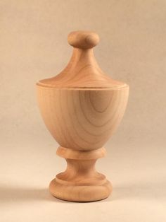 a wooden vase sitting on top of a white table